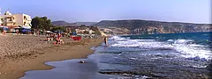 Strand von Kommos in Kalamaki auf Kreta mit Badegästen, Strandschirmen und Klippen