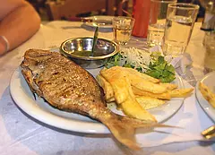 Gegrillte Dorade mit Pommes und Salat auf einem Teller in einem kretischen Restaurant